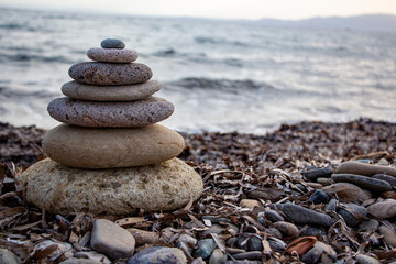 Stack of zen stones on the beach. Zen and harmony concept. Pyramid of pebbles on the beach at sunset. Stack of zen stones on the seashore. Zen concept