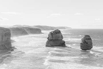 Twelve apostles rock formations, sea stacks with sea spray on cliffs, black and white monochrome...