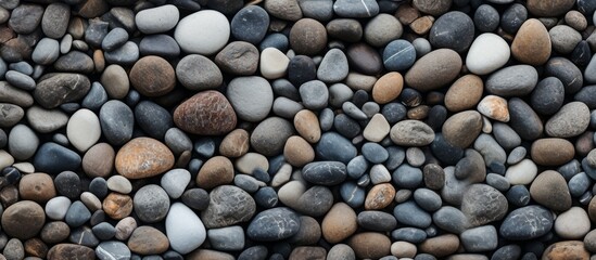 A diverse collection of rocks including bedrock, cobblestones, pebbles, and gravel scattered in a pattern resembling artwork for use as building material or flooring. Reminiscent of a funeral cairn
