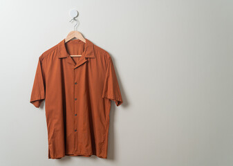 shirt with wood hanger on wall