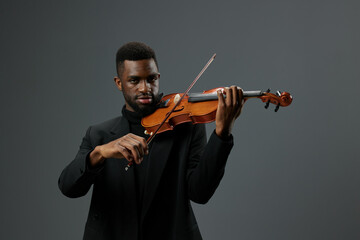 Talented African American Man in a Suit Playing the Violin on a Gray Background