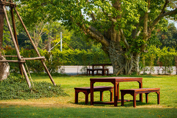 Set of wooden tables and chairs for relaxing. Located on the green grass