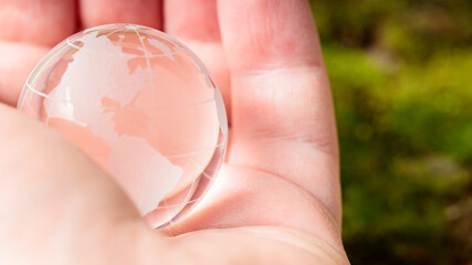 Transparent Glass Globe Held in Man's Palm, Concept of Earth Day and Environmental Protection