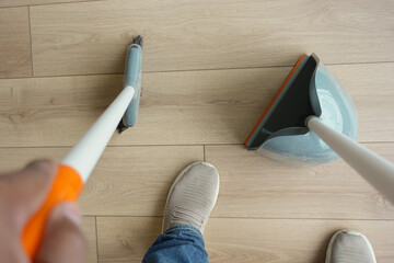top view of men suing floor dust with dust pan 
