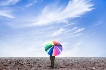 lonely woman holding umbrella standing on dry ground with blue sky cloudy. umbrella standing on dry...