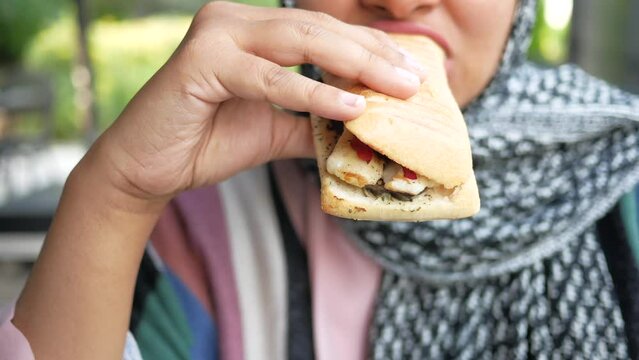 women eating Sandwich with ham, cheese, tomatoes
