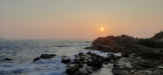 Sand beach among rocks on evening sunset. Ursa Beach near Cape Roca (Cabo da Roca) at Atlantic...