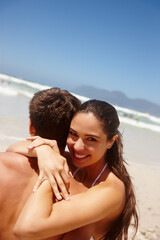 Couple, beach and hug on sand with romance for bonding, summer vacation and portrait with blue sky....
