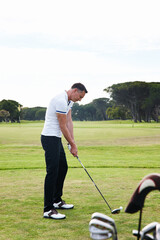 Man, golfer and playing with club on golf course for game, match or outdoor sport on green grass or field in nature. Male person or player with ball on lawn for competition or swing down fairway