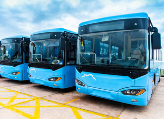 Many electric driven new energy buses are neatly parked in outdoor parking lots