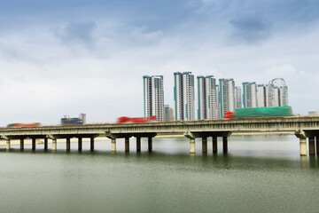 From the riverbank in the city, you can see the highway bridges on the river and the towering...
