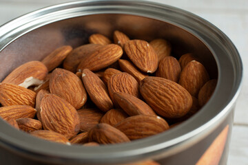 A closeup view of a canister full of almonds.