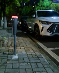 Modern intelligent parking timing and toll collection equipment, with cars parked on the roadside...