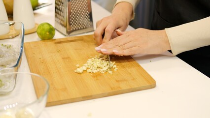 Witness as woman skillfully slices garlic cloves with a knife, demonstrating the art of garlic...