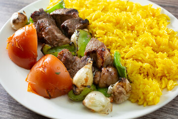 A view of a plate of beef kabobs.