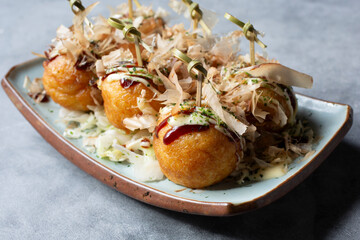 A view of a plate of takoyaki.