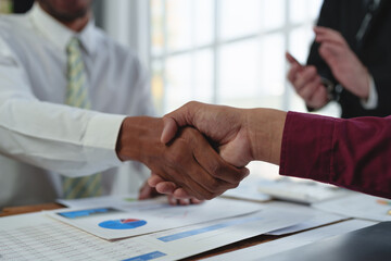 Young business people shaking hands in the office. Finishing successful meeting. Three persons....