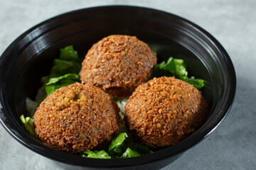 A closeup view of a bowl of falafels.