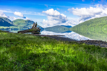 Nitinat Lake British Columbia morning landscape with blue sky, clouds and water reflection