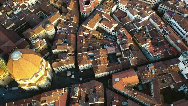 Aerial view rotating over rooftops in Florence city, golden hour in Tuscany, Italy
