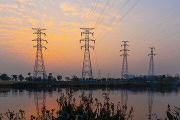 In the evening, the high-voltage power tower stands tall and spectacular in the park on the...