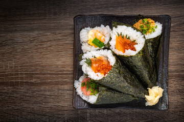 Japanese style of temaki with shrimp, caviar, fish on black plate, Asian food, traditional Japanese food, copy space