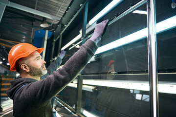 Man performs pressing of a double-glazed window in window production