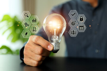 Close up hand choose light bulb or lamp with bright and business icons for human resources or leadership and creativity thinking idea motivation or vision and knowledge learning.