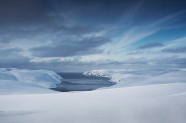 impressive weather conditions and a snow covered landscape with a fjord in northern norway