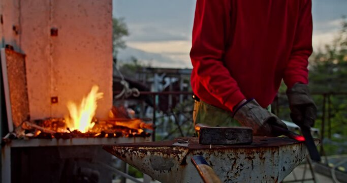 Blacksmith Forging Hot Metal By Scraping Outdoor. medium shot
