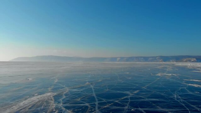 The natural shades of blue winter ice on Lake Baikal, looking from above, form a beautiful and unique background, ideal for winter themed designs and compositions.