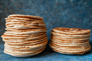 Flatbread lavash, chapati, naan, heap of tortilla on a blue background Homemade flatbread stacked.