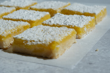 Homemade lemon bar squares with powdered sugar.