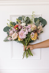 Vibrant bridal bouquet against a white frame backdrop