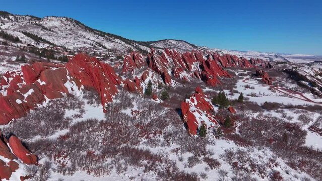 March winter morning after snowfall stunning Roxborough State Park Littleton Colorado aerial drone landscape sharp jagged dramatic red rock formations Denver foothills front range blue sky circle left