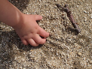 砂遊びをする女の子の手