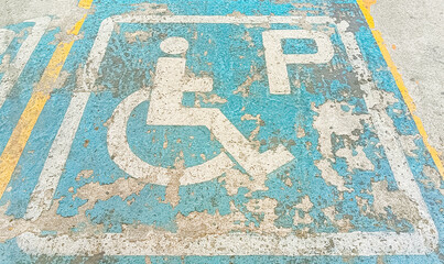 Fototapeta premium Disabled parking lot with scuffed paint or Disabled Sign On Road At Parking Lot