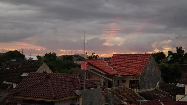 Timelapse of beautiful sunlight behind clouds in the afternoon at a housing estate