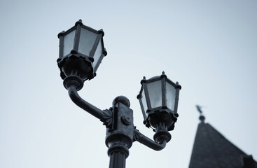 vintage street lamp made of forged metal on the background of the evening sky	