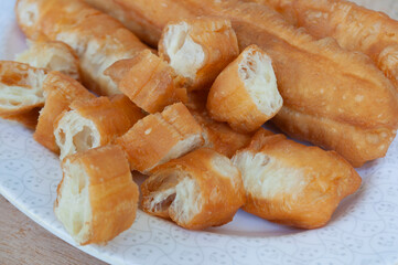 Close up view of cut cakoi or youtiao cake on white plate. Asian food concept