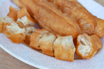 Close up of cut cakoi or Youtiao on white plate. Asian food concept