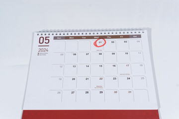 A spiral desk calendar of May page on the white background. 1st May marked or circled as Labour Day. 