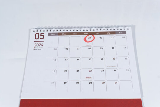 A spiral desk calendar of May page on the white background. 1st May marked or circled as Labour Day. 