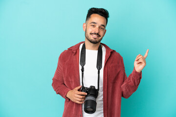 Fototapeta premium Young photographer caucasian man isolated on blue background showing and lifting a finger in sign of the best