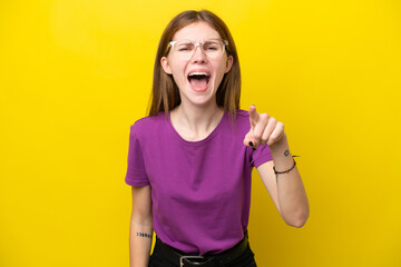 Young English woman isolated on yellow background frustrated and pointing to the front