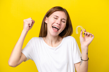 Young English woman holding invisible braces celebrating a victory - obrazy, fototapety, plakaty