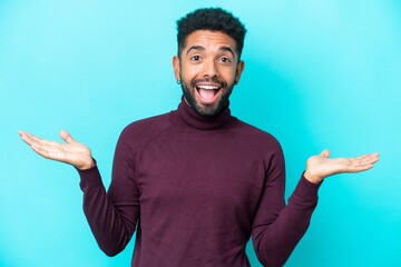 Young Brazilian man isolated on blue background with shocked facial expression