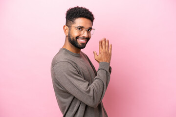 Young Brazilian man isolated on pink background scheming something