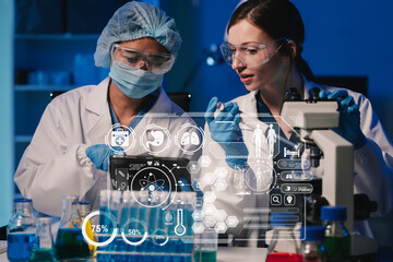 Team of biochemical research scientists working with a microscope for vaccine development in...