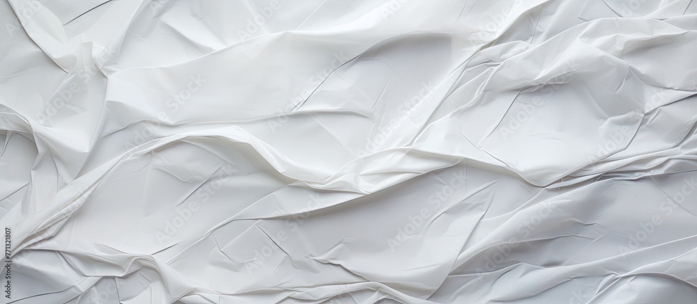 Poster a white fabric displaying intricate creases and folds with a textured paper background featuring wri